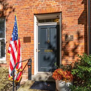 Brick entrance with blue door and American flag.